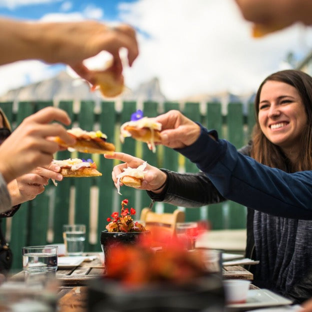 Edmonton-things-to-do-best-restaurants-Edmonton-first-date-ideas-biking-tours-best-restraunts-downtown-Edmonton-fun-date-ideas-edmonton-lil- bite-bike-tour-electric-bike-group-of-people-cheering-with--food-appetizers