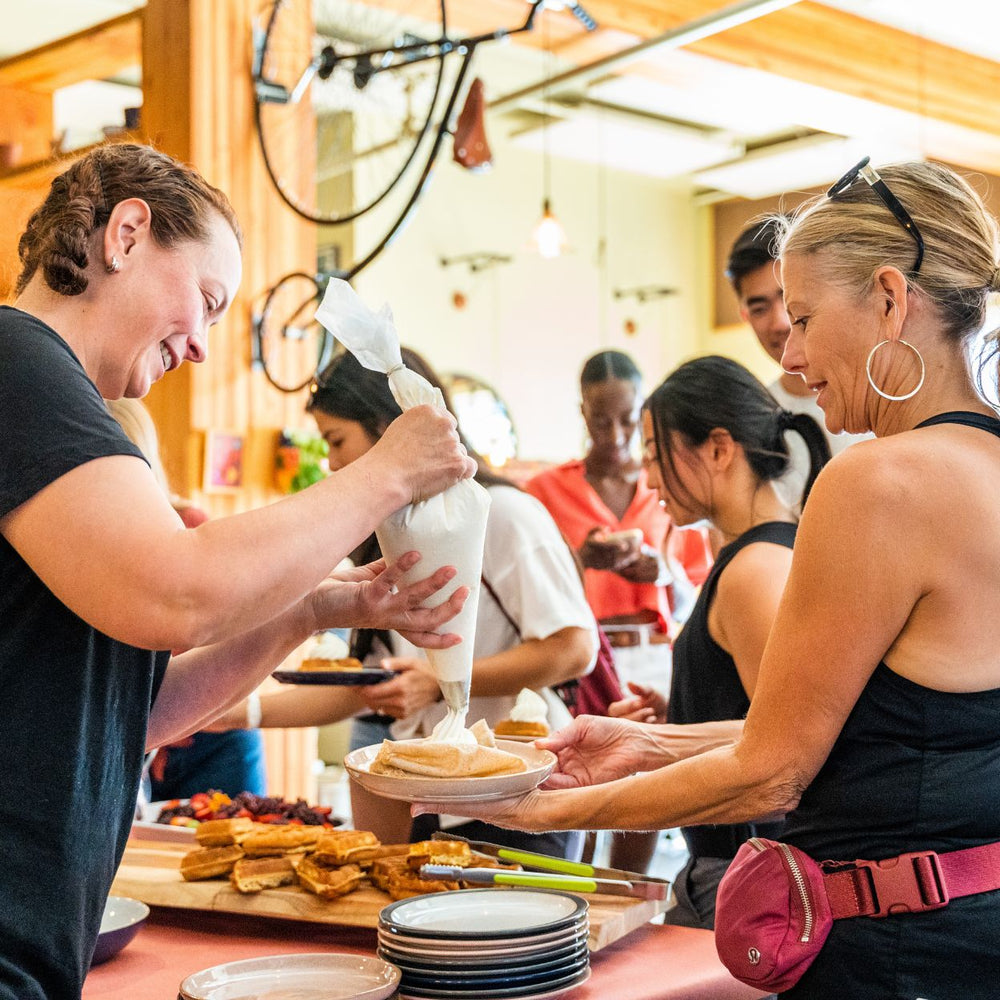 Best-restaurants-Edmonton-fun-date-ideas-Edmonton-summer-brunch-Edmonton-biking-tours-Under-the-high-wheel-owner-Jennifer-decoratin-waffle-of-guest-on-food-bike-tour-Alberta-Tours