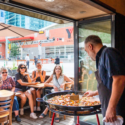 Best-restaurants-downtown-Edmonton-date-breweries-Edmonton-active-date-ideas-fun-girls-nights-Lino-Oliveira-showing-guests-on-food-bike-tour-how-to-make-a-paella-at-his-restaurant-in-Sabor-food-tasting-tour