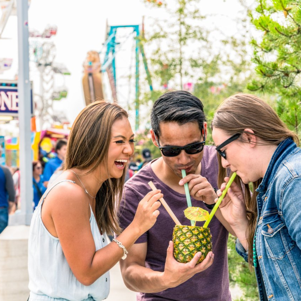 Edmonton-things-to-do-best-restaurants-Edmonton-Alberta-glamping-breweries-Edmonton-biking-tours-best-restraunts-downtown-Edmonton-fun-date-ideas-edmonton-food-bike-tour-group-of-friends-drinking-pineapple-drink-from-K-Days-summer-festival