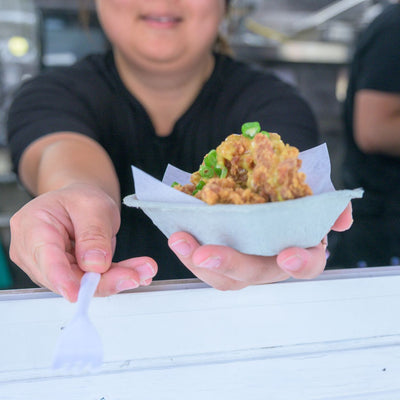 Edmonton-things-to-do-best-restaurants-Edmonton-cute-date-ideas-Edmonton-biking-tours-best-restraunts-downtown-Edmonton-fun-date-ideas-edmonton-taste-of-edmonton-adventure-biking-Alberta-tours-lady-handing-out-food-and-fork-in-food-truck-festival