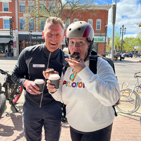 Edmonton-things-to-do-best-restaurants-Edmonton-fun-date-ideas-Edmonton-adventure-Edmonton-couple-taking-a-bite-of-a-doughnut-on-whyte-ave-pact-coffee-food-bike-tour